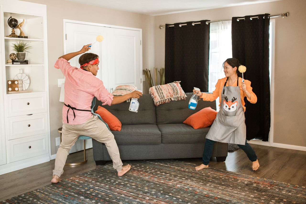 heros-img A cheerful couple is caught in a playful cleaning battle in their living room, reflecting a fun and carefree home life.
